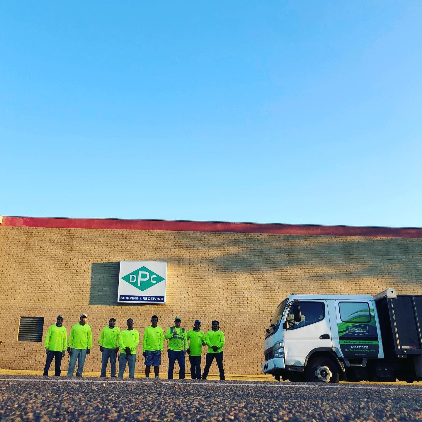 NexGen crew lined up in front of a commercial building with the company truck